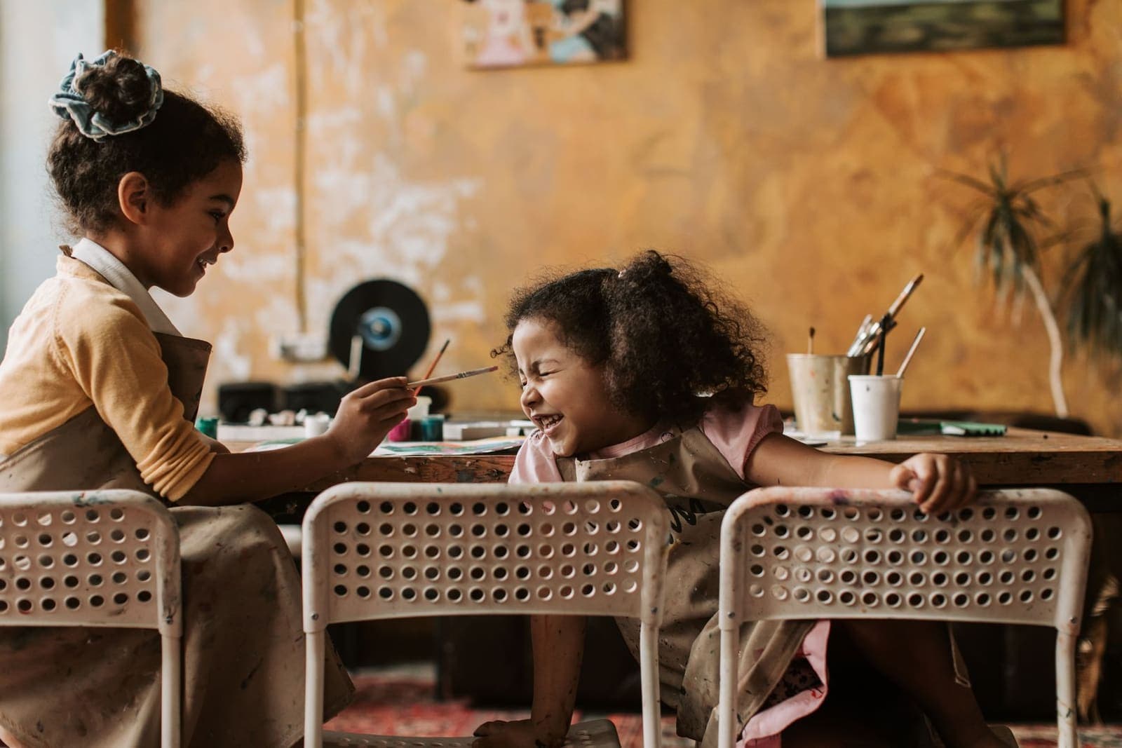 Two girls painting together during a creative arts session
