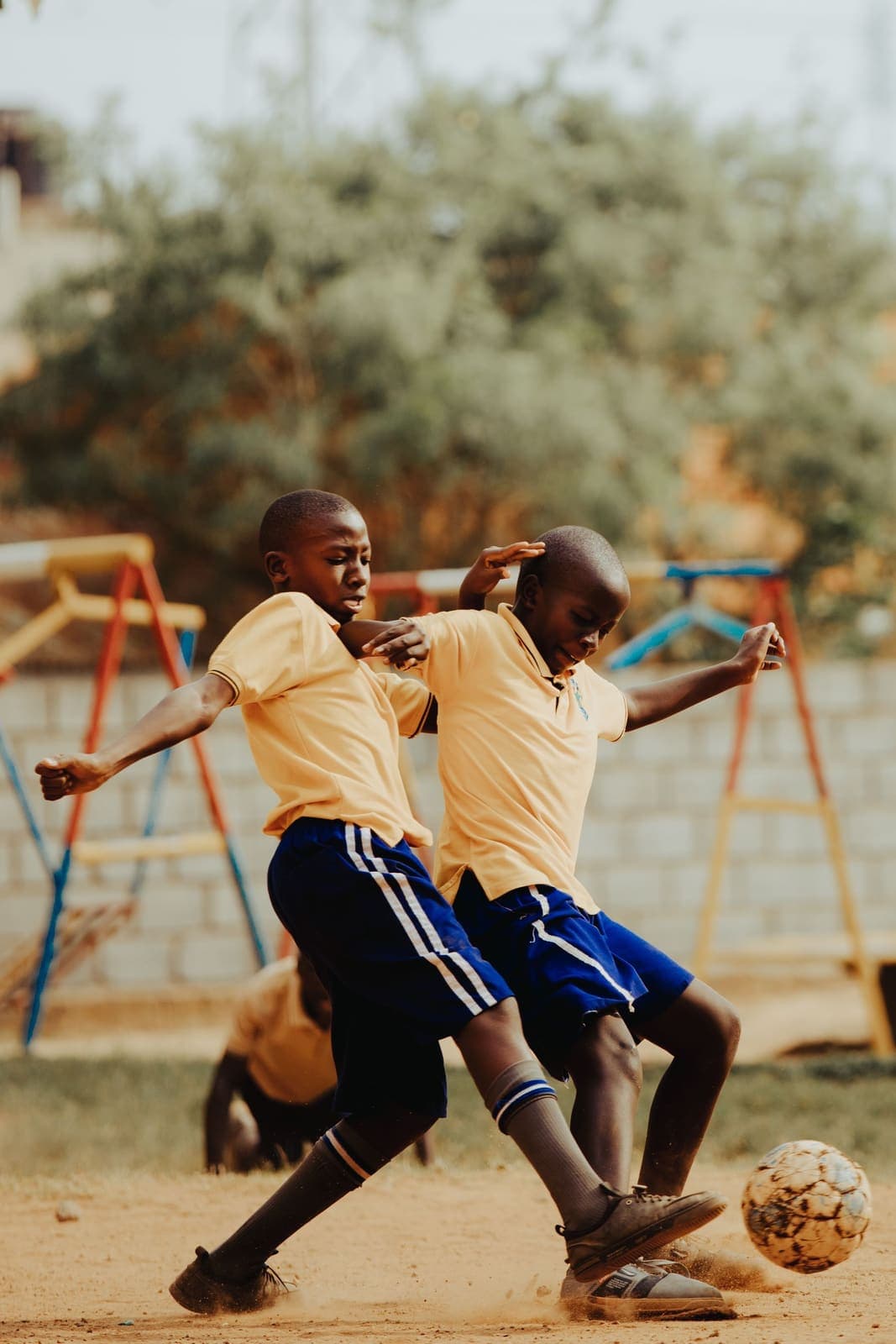 Two pupils racing each other across a sunny school field