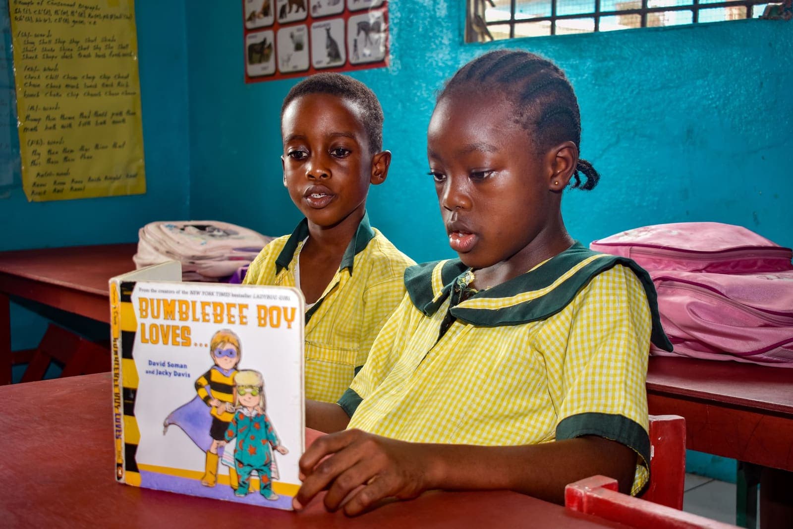 Two pupils sharing a storybook together in class