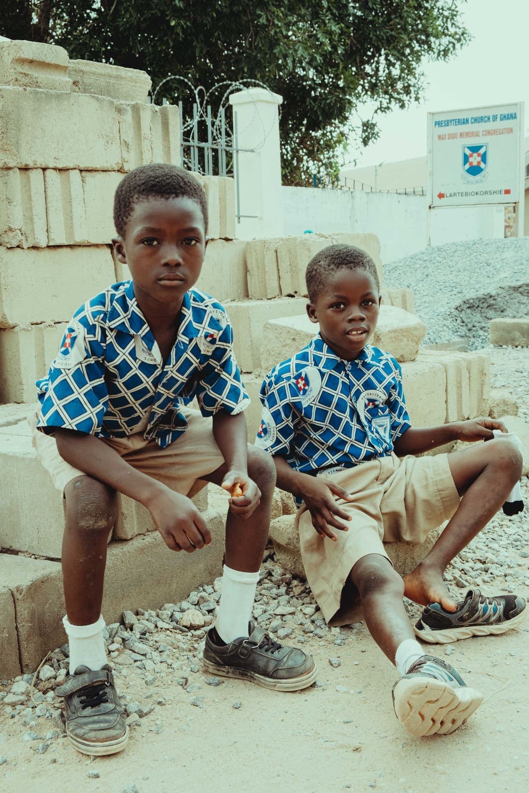 Two schoolboys in uniform standing together outdoors in Accra, Ghana