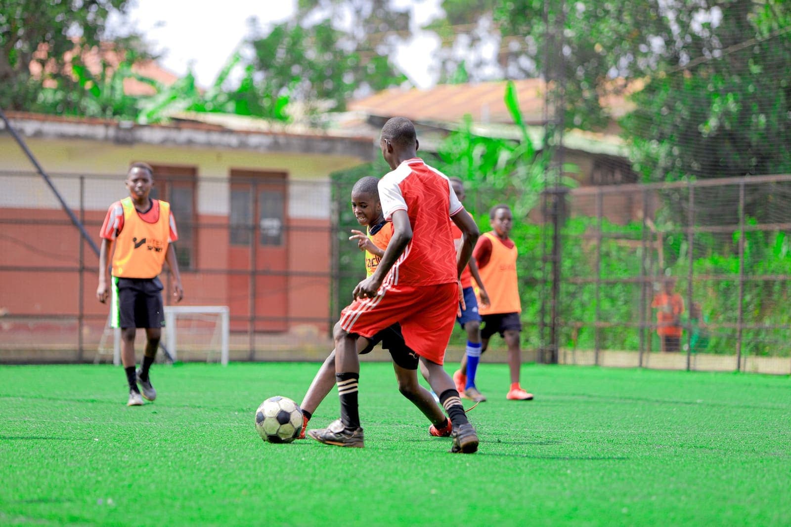 Children playing a game of football on a school sports field