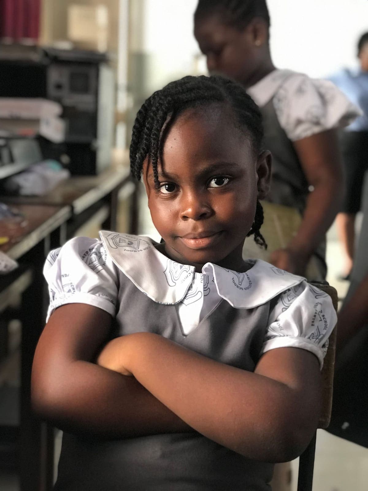 A confident schoolgirl in Ghana smiling in her classroom