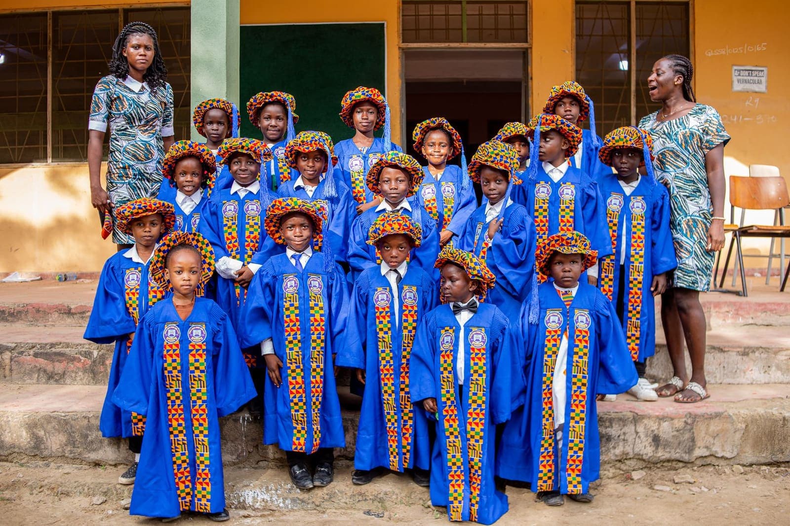 Pupils in graduation gowns gathered outside their school in Ghana
