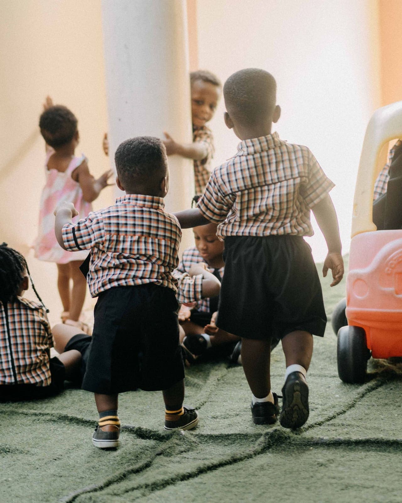 Young children in school uniform playing together during an early years session