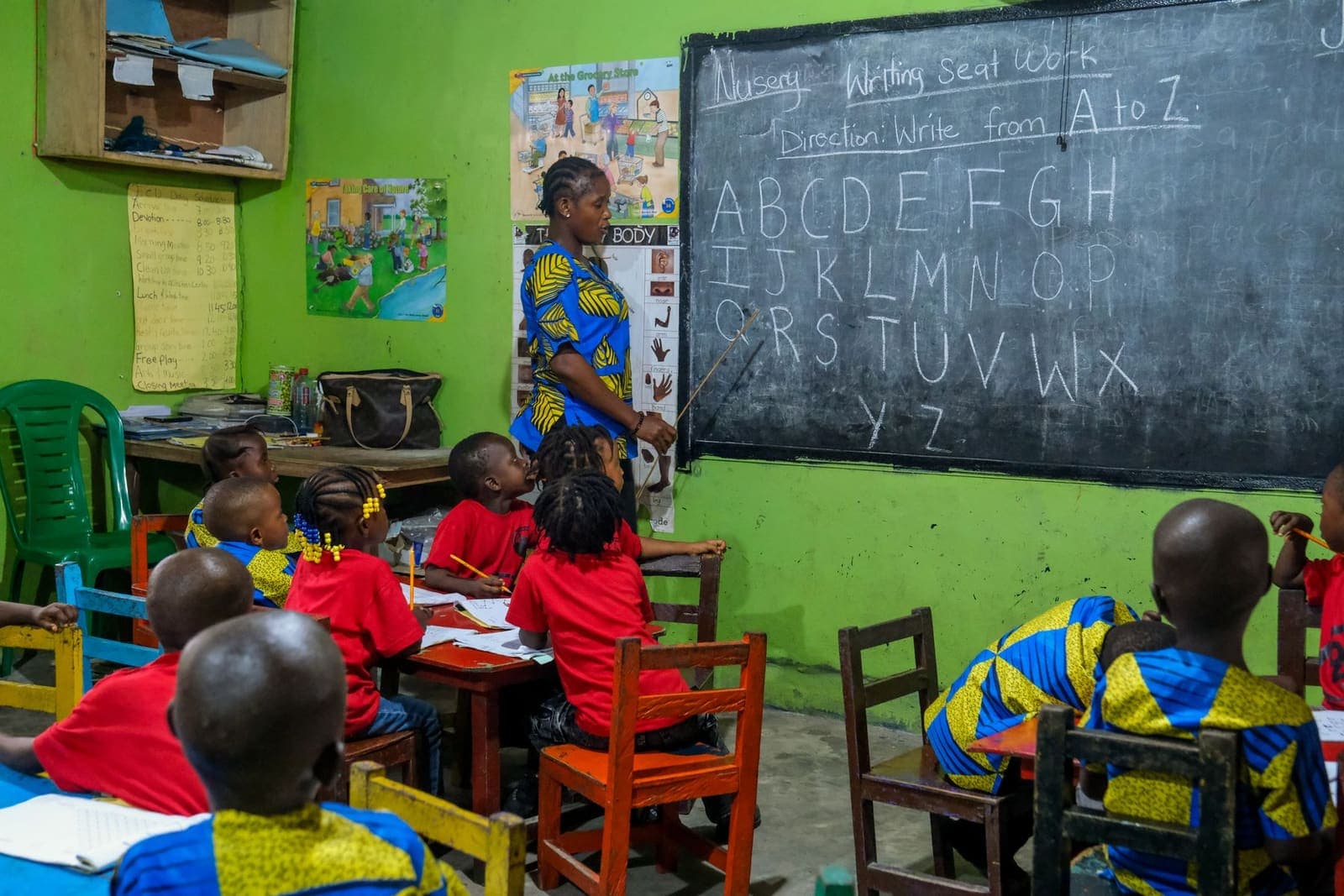 A teacher leading an alphabet lesson with young learners