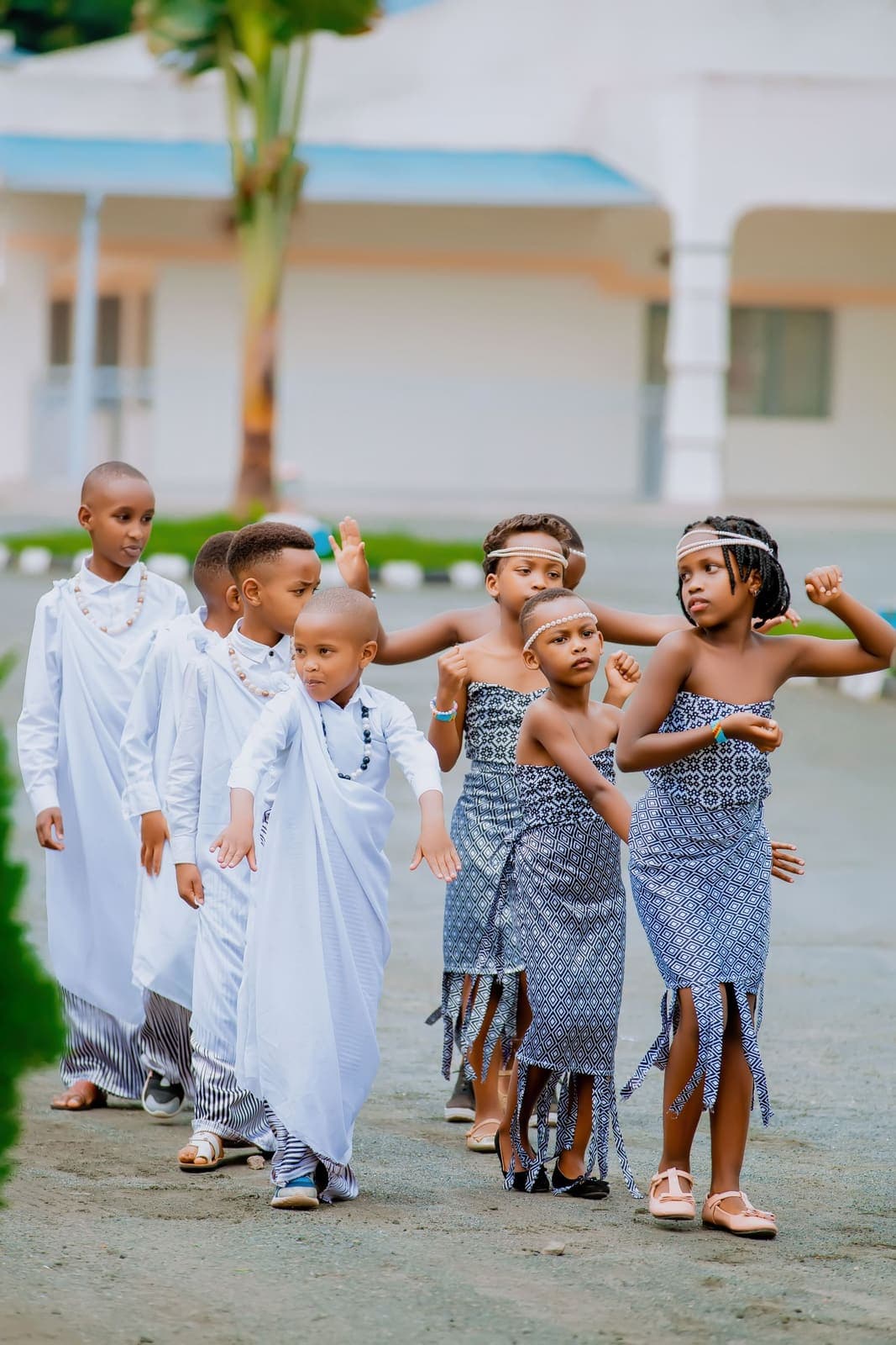 Children in cultural dress dancing together at an outdoor school celebration